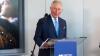 A picture of His Majesty King Charles III standing at a lectern in front of the microphone giving a speech at the British Council's Stratford office.